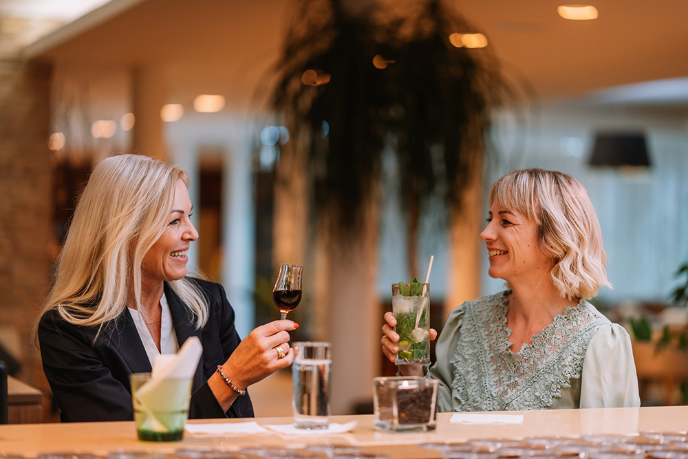 Zwei Damen genießen Cocktails und Drinks in der Hotelbar
