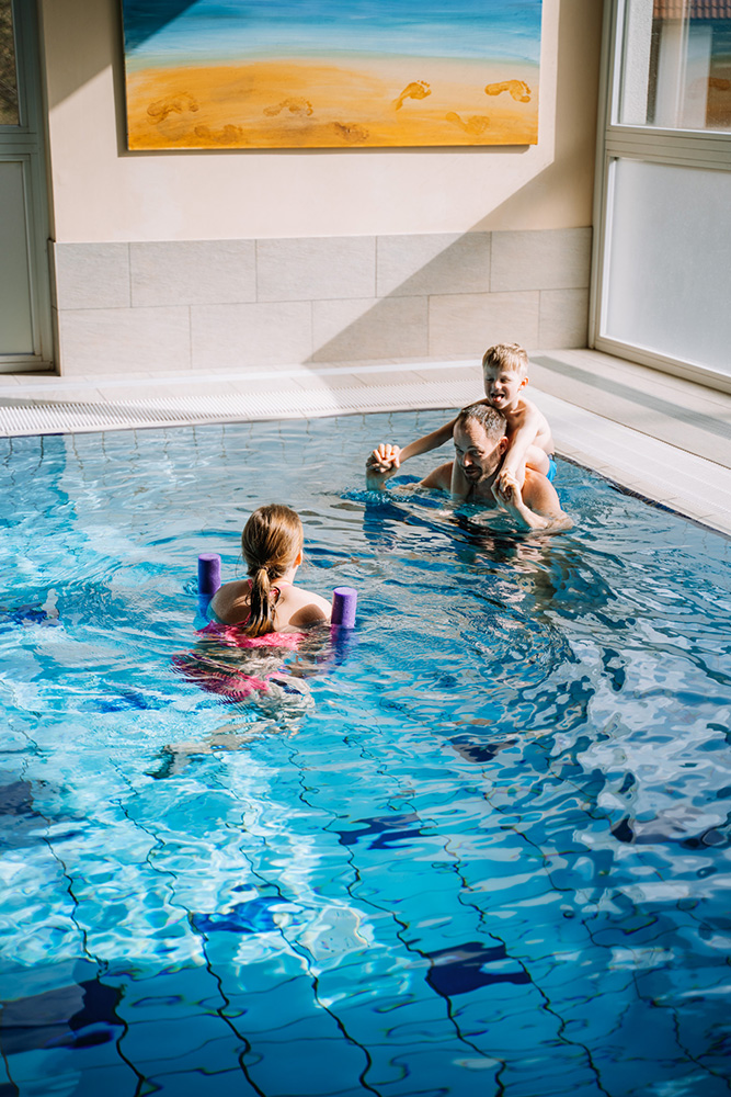 Familie beim Baden im Indoor-Pool des Auszeit Hotels