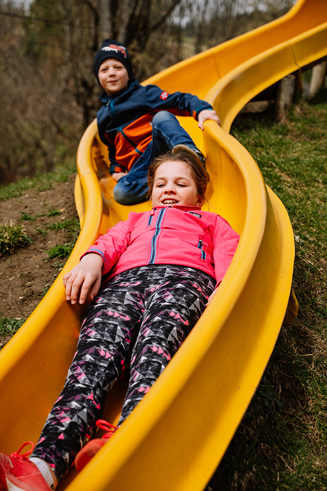 Kinder rutschen am Erlebnis-Spielplatz