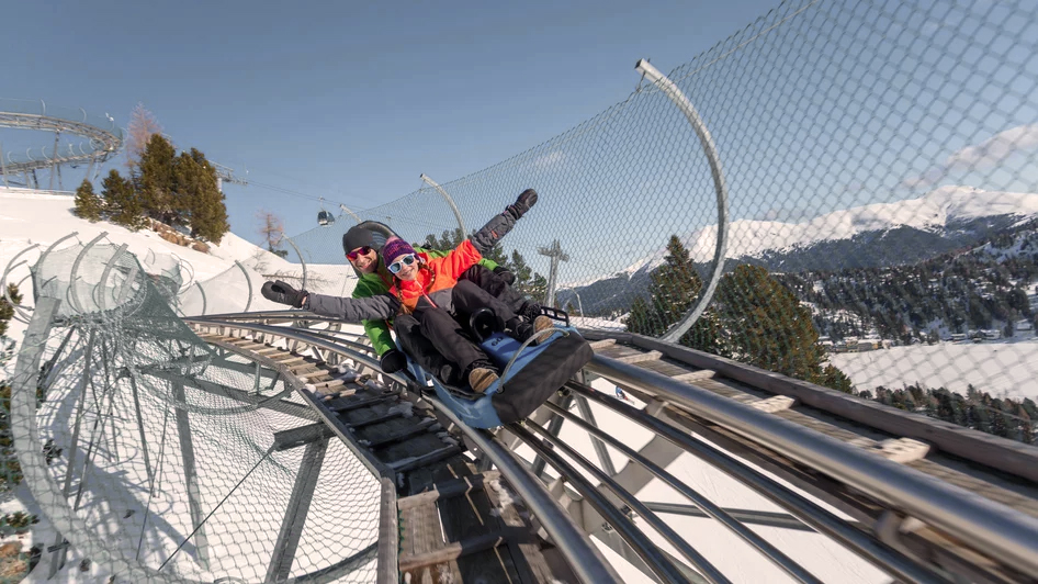 Familie testet die Alpen-Achterbahn beim Skiurlaub mit Kindern Österreich