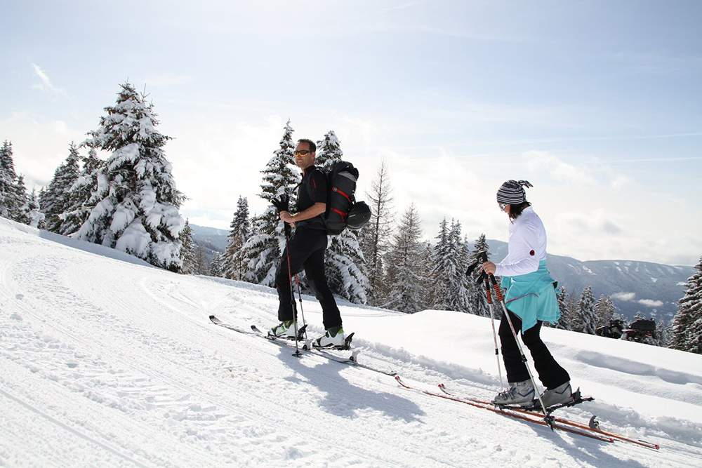 Paar erkundet Murau bei einer Skitour im Winterurlaub in Österreich