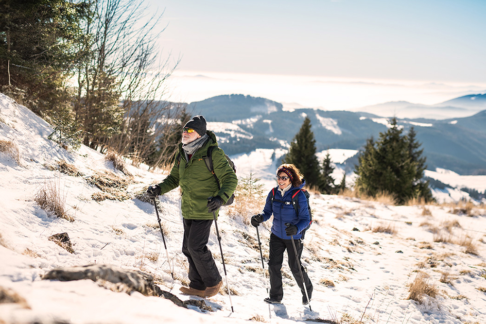 Bestager-Paarb beim Nordic Walking durch die Winterlandschaft beim Winterurlaub in Österreich